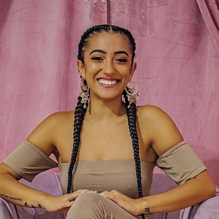Ryin Amber Lokietz smiling in a pink velvet armchair