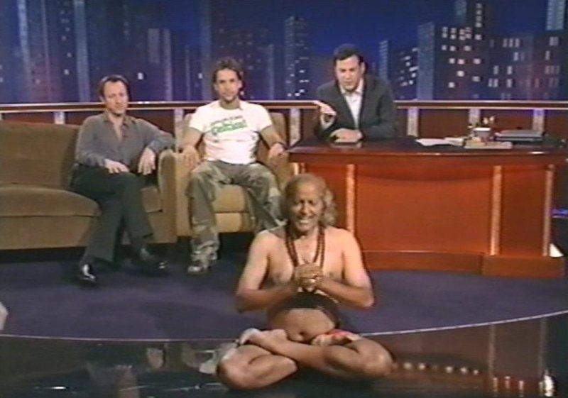 Yogi Ramesh Pandey seated in a yoga pose on the Jimmy Kimmel Live set