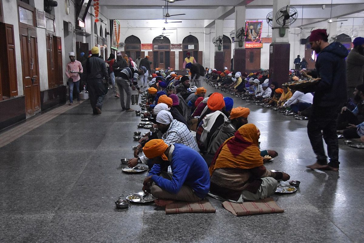 Visitors seated on the floor and served a free meal in the Golden Temple langar, Amritsar