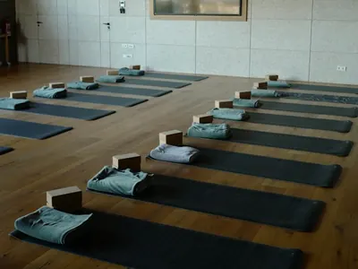 Empty yoga studio with mats and blocks laid out on a wooden floor